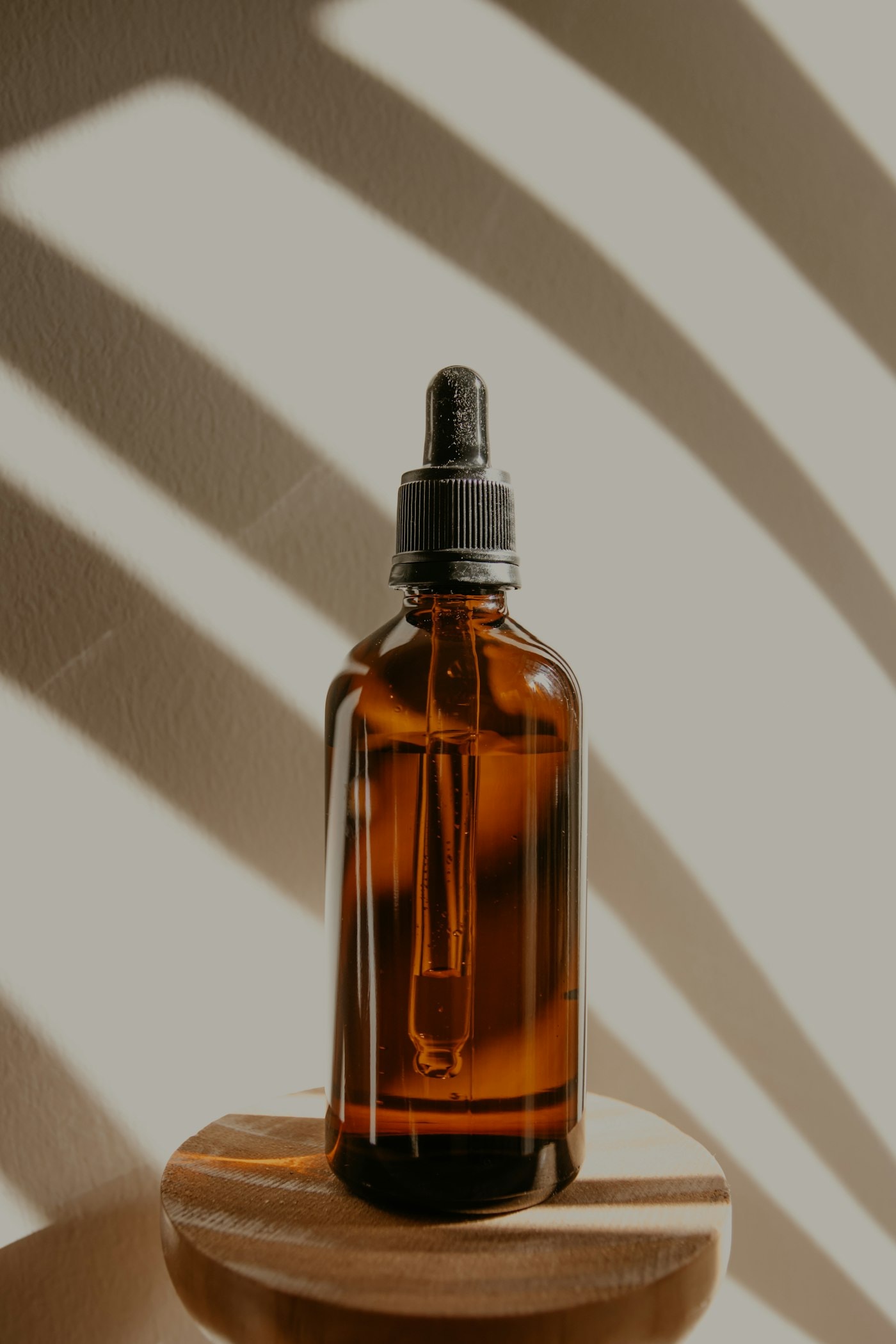 Amber serum bottle catching soft shadows