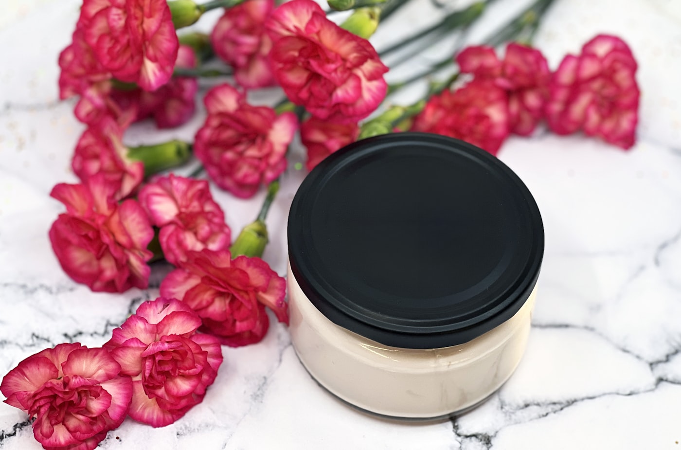 Moisturiser jar beside fresh flowers