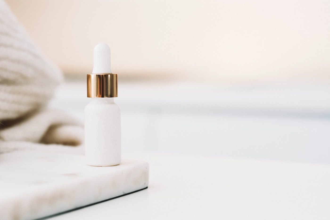 White dropper serum bottle on marble